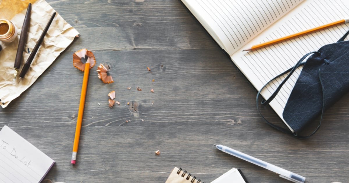 A writing desk with notes and a pen