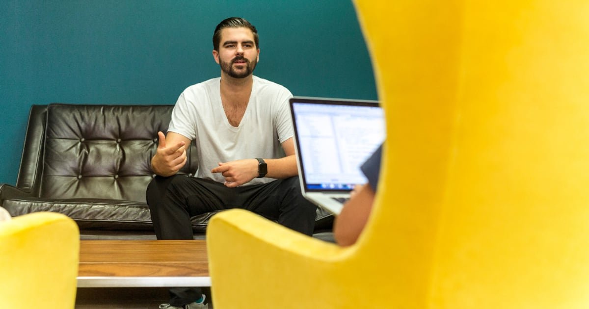 A man in a meeting with a laptop
