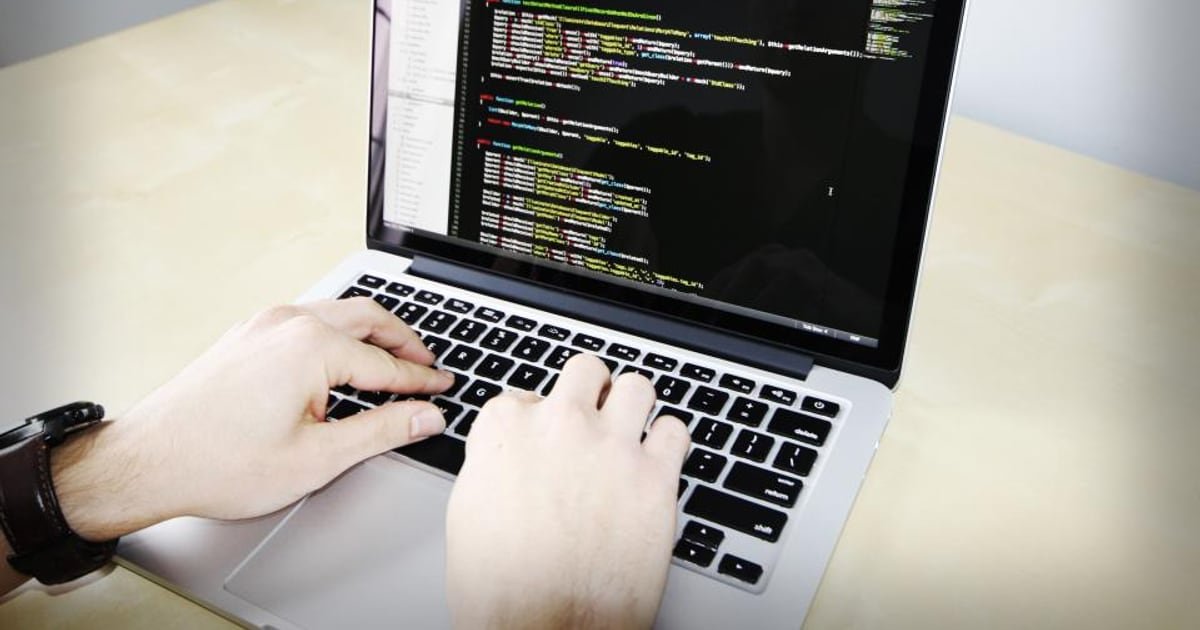 Code on a laptop in an office